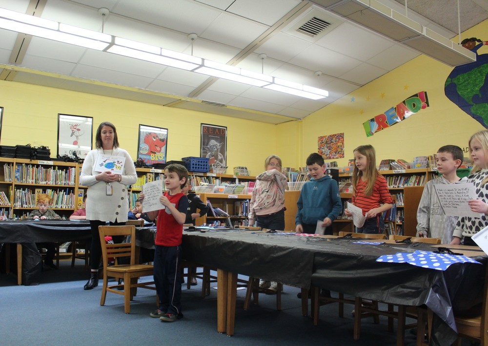 Students and teacher standing in library
